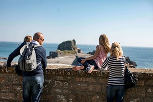 A family of 4 look out over Hermitage Rock from Elizabeth Castle in Jersey