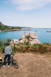 couple with bikes looking over jersey channel island sea