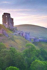 view of corfe castle dorset with green countryside and beautiful sky
