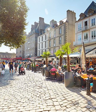 st malo street with people sitting outside eating in the sun